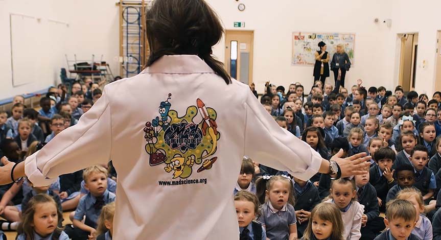 Mad Scientist at special event presenting to room full of children sitting on the floor