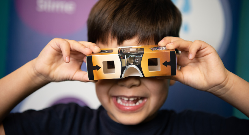 A boy playing with our Stereoscopic Viewer take-home from our NASA Academy of Future Space Explorers program.
